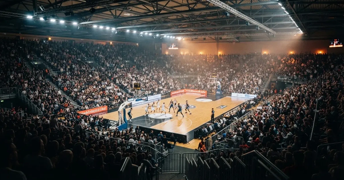 Een volle sporthal onder schijnwerpers, van grote afstand gefotografeerd